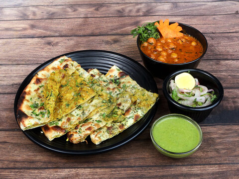 Chole Kulcha, Clay Baked Stuffed Naan Served With Channa Masala Or Chole Masala, Typical Meal Of Amritsar, India. Isolated Over A Rustic Wooden Background, Selective Focus