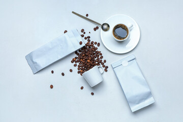 Composition with coffee bags and beans on white background