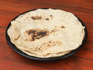 Tandoori Roti, isolated over a rustic wooden background, selective focus