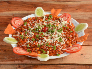 Taco Salad Made of Beef Cheese and Lettuce, served over a rustic wooden background, selective focus