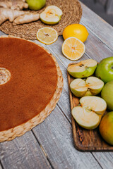 Lime and ginger fruit leather with fresh fruits on the wooden table. Round fruit leather. Healthy food. Apples, bananas, lime, ginger top view.