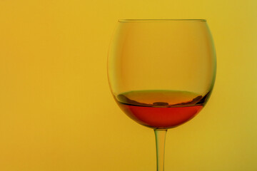 A glass of cognac isolated on a yellow background