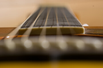 Detail of six guitar strings along the fretboard