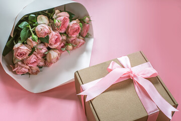 Pink roses bouquet and gift box on pink background, Valentine's day background