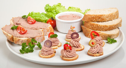 plate with slices of bread with home made pate, decorated with vegetables