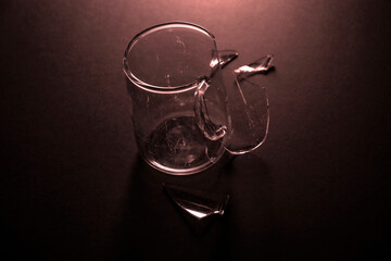 
crushed glass cup, fragments scattered, isolated on black background.