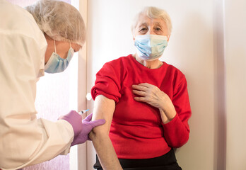 doctor vaccinating a nice senior woman- vaccination against winter desease