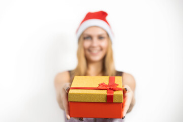 A glamorous young woman holds a Christmas present in her hands. A wonderful female model is preparing for a new year's party