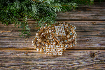 Top view Christmas background with belt of gold, crystal white stones and pearls . Fir tree on wooden table with copy space.