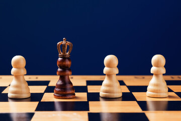 Black pawn in crown among whites on chess board. Personal Growth concept