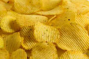 One of the types of snacks, fast food, junk food - ruffled potato chips on a white background. Background of potato chips