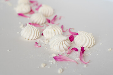 meringue on a white table with pink petals
