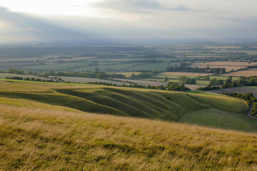 Fototapeta na wymiar Curved grasslands seen from above at sunset from White Horse Hill Uffington 