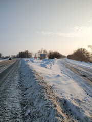 Fototapeta na wymiar Winter landscape. A road covered with white snow. The car is driving along the road