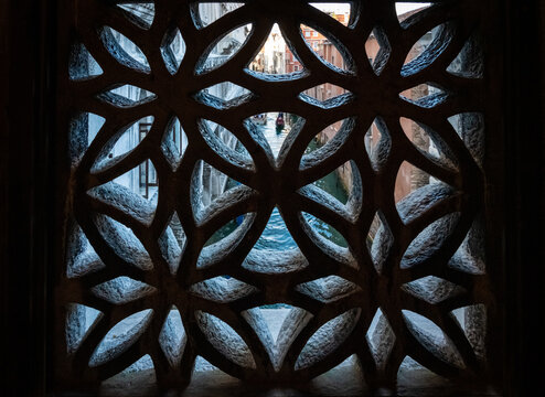 Blick durch ein Fenster der Seufzerbr&uuml;cke des Palazzo Ducale auf einen Kanal in Venedig mit Gondel