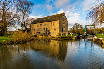 A view toward an old mill on the River Nene at Oundle, UK on a bright sunny day