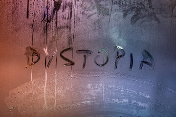 the word dystopia handwritten on wet window glass surface