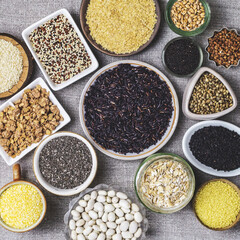 Food background of various cereals and grains in plates on a canvas