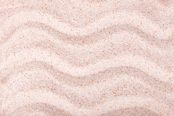 .Sea sand with painted waves.Texture background..Top view..Soft focus.Concept of decoration,design,summer beach,holidays.