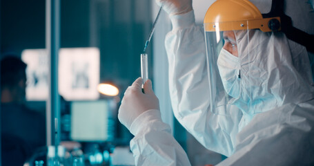 Scientist pouring vaccine into flask