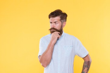 brutal bearded hipster with groomed beard is professional barber in white shirt, barbershop
