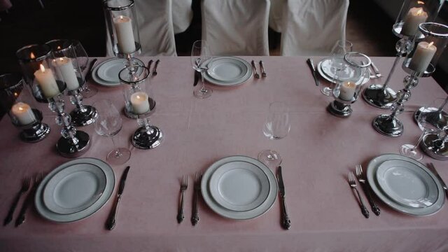 Glasses and plates on a banquet table. Night Party at a fancy restaurant. Festive time, celebration event on holidays. Beautiful decoration on tables. 