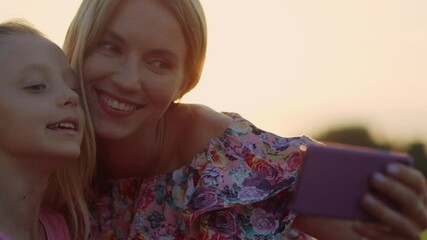 Cheerful family posing in city park. Woman showing tongue to camera outdoor.