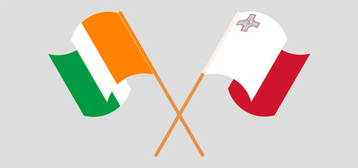 Crossed and waving flags of Malta and Republic of Ivory Coast