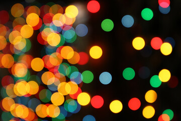 Christmas lights, defocused colorful abstract background. Blurred bokeh with golden, green, red and blue shining lights, New Year holiday texture, decorations on the night street
