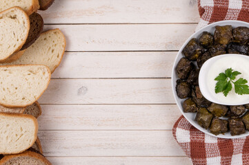 Traditional azerbaijan dolma in grape leaves on white wooden table with copyspace.  Oriental dish .  Traditional georgian tolma in vine leaves on rustic background with copyspace. Turkish dish