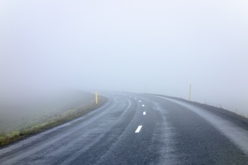 Asphalt road in Iceland at misty weather lowering the visibility and safety with motion blur effect when travelling