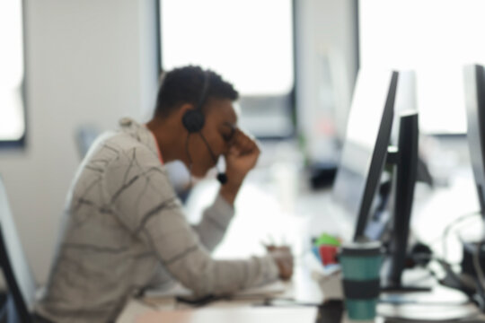 Tired businesswoman with head in hands at computer desk