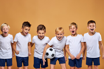 kids soccer players celebrate a winning in school sports tournament, studio portrait of happy...