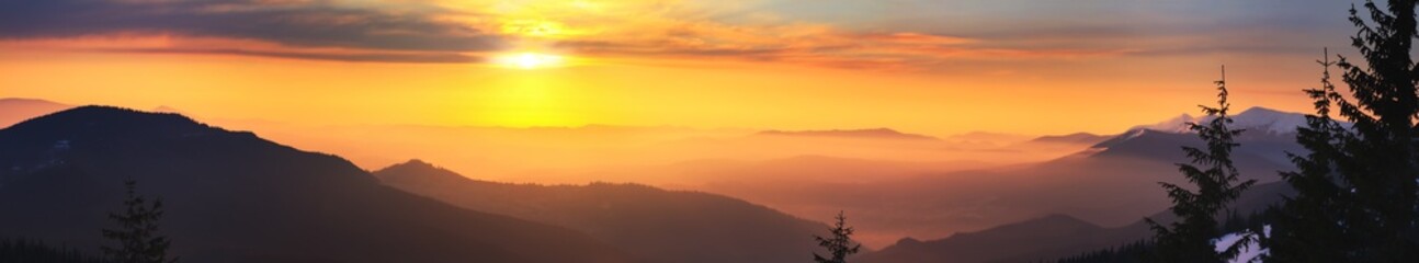 Winter landscape at sunrise, panorama, banner - view of the mountain range covered with forests, Carpathian mountains in Ukraine