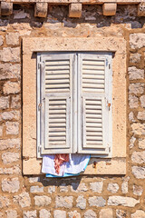 Summer cityscape - view of the window closed from the heat by shutters in the Old Town of Dubrovnik on the Adriatic Sea coast of Croatia