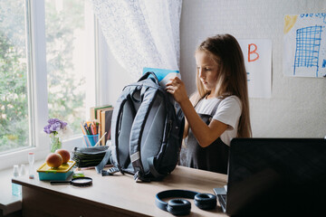 Back to school, schoolchildren hygiene, safety precautions after coronavirus. The schoolgirl is going to school and washing her hands with sanitizer