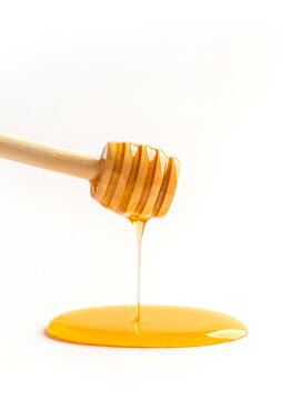 Honey dripping off a wooden honey dipper.