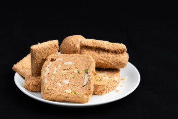 Special Indian Til Gul Khasta Gur Ke Gajak Barfi Gazak Rolls Laddu And Gud Patti Chikki Made Of Dough From Hammered Sesame Seeds Moongfali For Makar Sankranti Bihu And Lohri Treat. Black Background