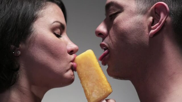 Man and woman sensually sharing flavored ice