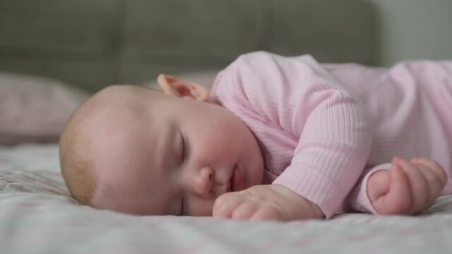 Close-up portrait of beautiful nice sweet newborn baby sleeping in bed. Concept of care happy family and child children baby parenthood childhood, Little nice girl lying on bed sleeping in room
