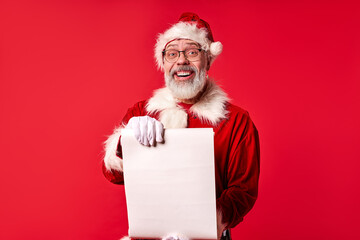 santa man in suit holding list paper in hands and looking at camera, smiling, xmas, new year concept