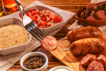Fork serving grilled pork sausage with chimichurri - Close up