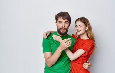 cheerful man and woman multicolored t-shirts embrace friendship emotions lifestyle