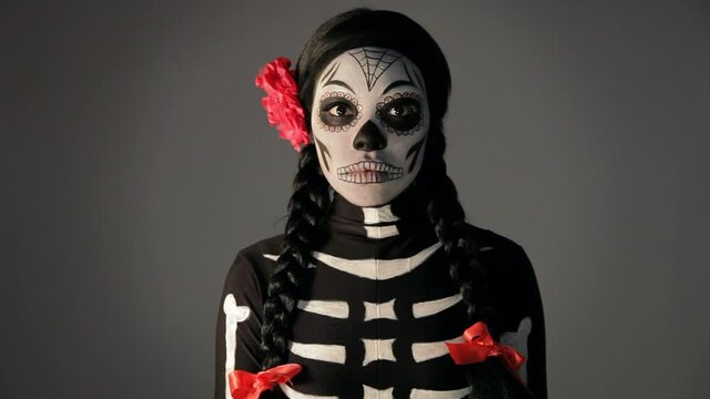 Woman wearing Day Of The Dead skeleton makeup and costume