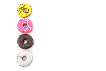 Fototapeta premium row of traditional American donuts with chocolate, pink, yellow, white icing and sprinkles isolated on white background. Copy space.