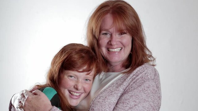 Portrait of mother and daughter with red hair hugging