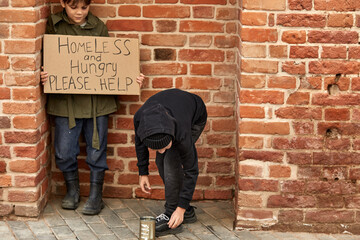 homeless kids poverty beggars asking for money and hoping help in helpless dirty city, holding cardboard box with HELP description on board. beggar in city concept