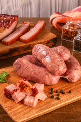 Raw brazilian bacon sausages on the wooden board with fresh cubes of bacon and spices - Linguiça de bacon