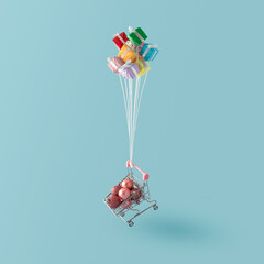Colorful gift boxes like balloons with christmas baubles flies in the blue sky. Creative concept