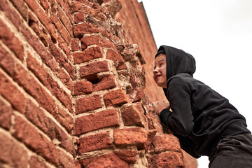 street child boy is playing the game with friends, climbing the building